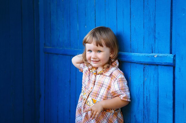 Portret van gelukkig blij mooi meisje tegen de oude geweven blauwe muur