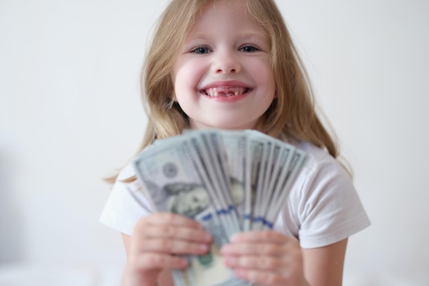 Portret van gelukkig glimlachend meisje met ventilator van dollars