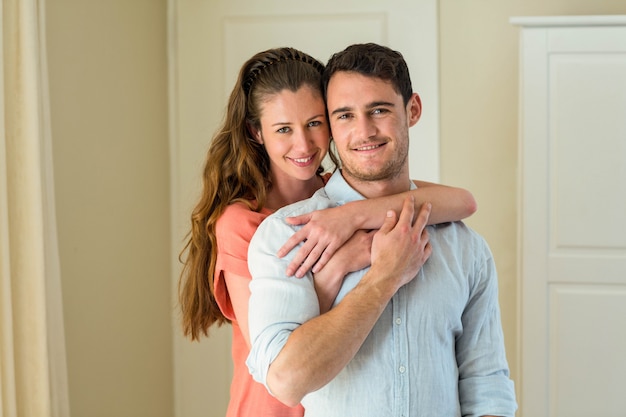 Portret van gelukkig jong koppel omarmen in de woonkamer