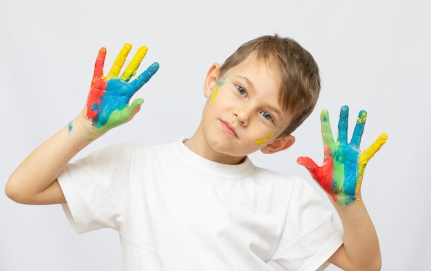 Portret van gelukkig jongetje met verf op handen geïsoleerd op witte achtergrond