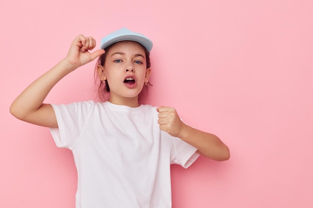 Portret van gelukkig lachend kind meisje poseren witte tshirt emotie roze achtergrond