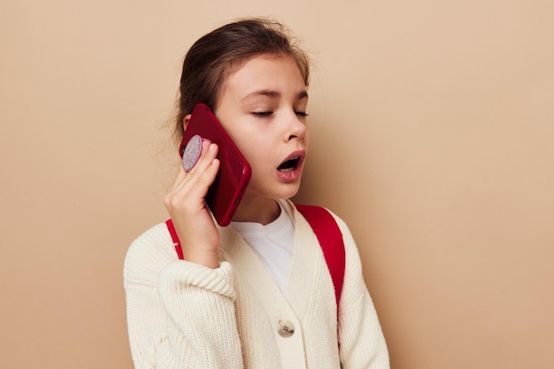 Portret van gelukkig lachend kind meisje schoolmeisje rugzak telefoon in de hand jeugd ongewijzigd