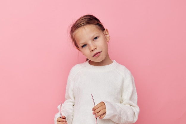 Portret van gelukkig lachend kind meisje witte trui poseren leuke geïsoleerde achtergrond