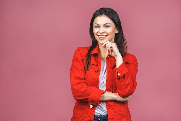 Portret van gelukkig lachende hipster vrouw in casual geïsoleerd over roze muur.