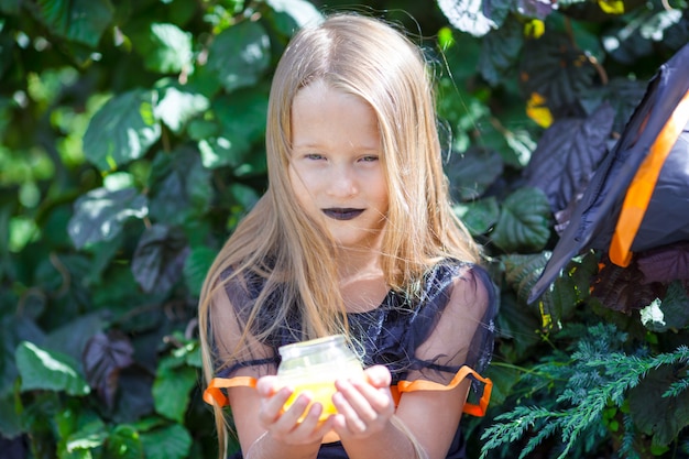 Portret van gelukkig meisje die heksenkostuum met bezem op halloween dragen