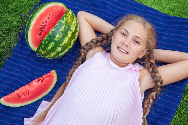 Portret van gelukkig meisje met watermeloen genieten van zomer buiten overdag.