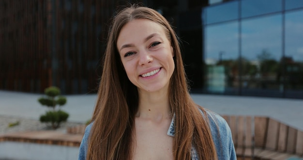 Portret van gelukkig meisje op zoek naar camera Close-up gezicht van mooie lachende vrouw met lang haar