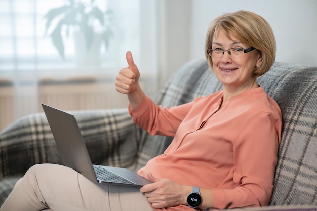 Portret van gelukkig positief mooie vrouw, oudere senior gepensioneerde dame freelancer thuis werken