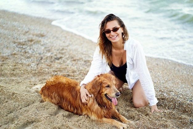 Portret van gelukkig schattige jonge vrouw zitten en knuffelen haar hond