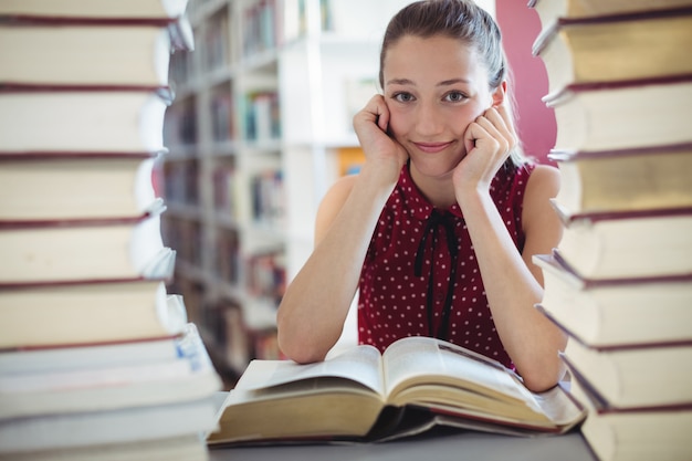 Portret van gelukkig schoolmeisje die bibliotheek bestuderen