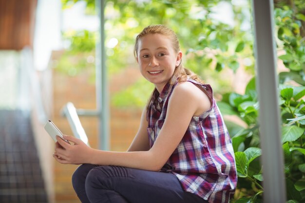 Foto portret van gelukkig schoolmeisje die mobiele telefoon houden