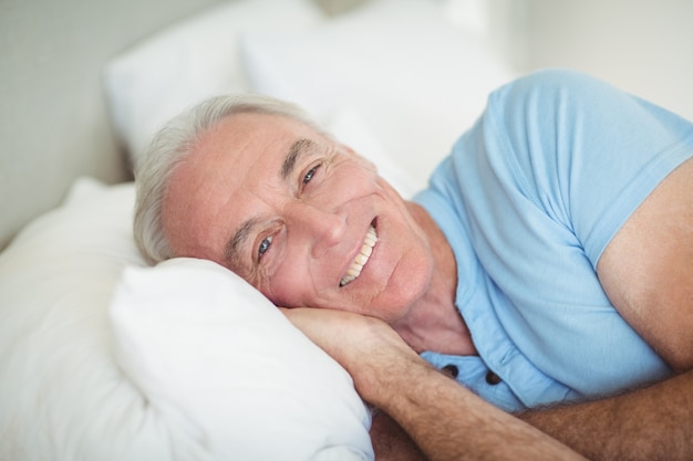 Foto portret van gelukkig senior man liggend op bed