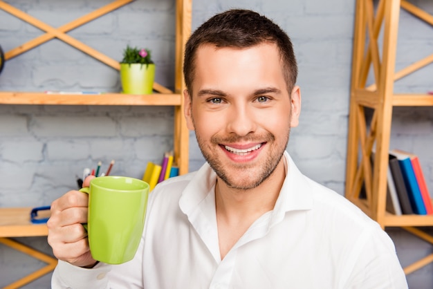 Portret van gelukkig succesvolle man met kopje koffie