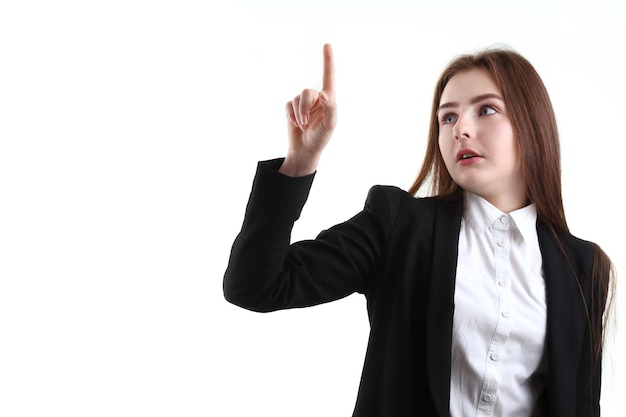 Portret van gelukkige aardige schoolmeisjestiener in wit overhemd op grijze studio als achtergrond