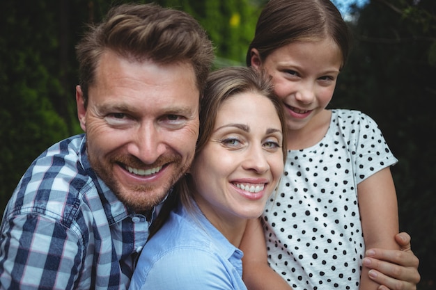 Portret van gelukkige familie die in park glimlacht