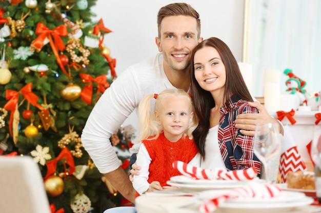 Portret van gelukkige familie in woonkamer ingericht voor Kerstmis