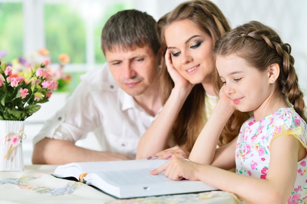 portret van gelukkige familie met boek thuis