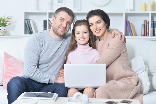 Portret van gelukkige familie met laptop thuis