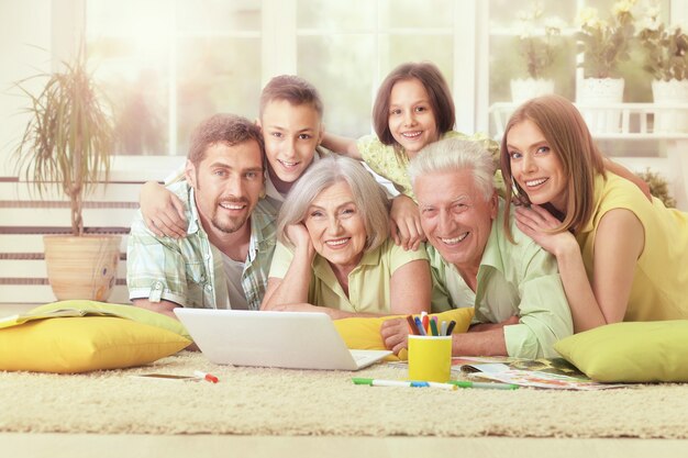 Portret van gelukkige familie thuis met laptop