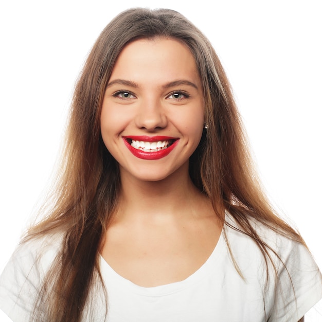 Portret van gelukkige glimlachende jonge mooie vrouw, die over witte ruimte wordt geïsoleerd
