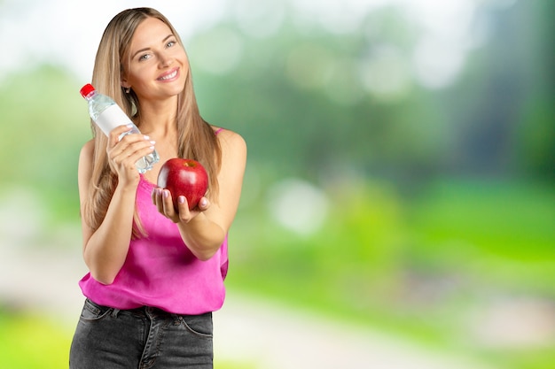 Portret van gelukkige glimlachende jonge mooie vrouw die rode appel eten