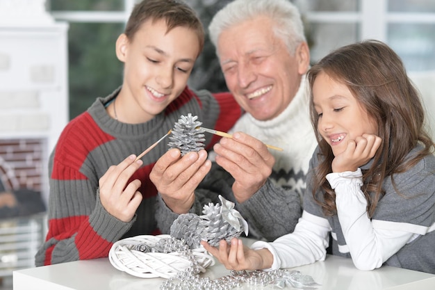 Portret van gelukkige grootvader met kinderen die zich samen voorbereiden op kerstmis