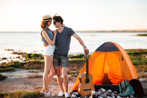 Portret van gelukkige jonge aantrekkelijke paar omarmen voor camping tent