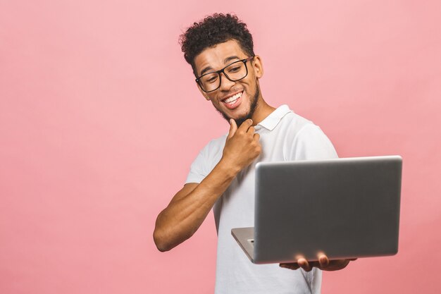 Portret van gelukkige jonge afro Amerikaanse man met behulp van laptop