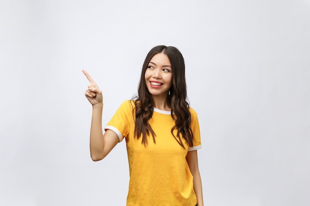 Portret van gelukkige jonge Aziatische vrouw met vinger omhoog