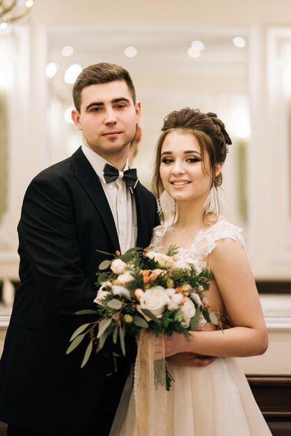 Portret van gelukkige jonge liefhebbers van de bruid en bruidegom in een luxe interieur. Trouwdag