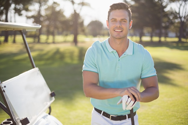 Portret van gelukkige jonge man met golfclub