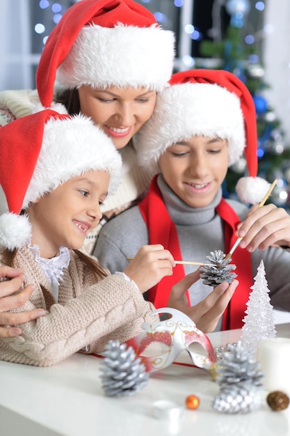 Portret van gelukkige jonge moeder en kinderen die zich voorbereiden op Kerstmis