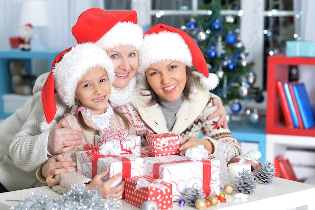 Portret van gelukkige jonge moeder, grootmoeder en dochter die zich voorbereiden op Kerstmis