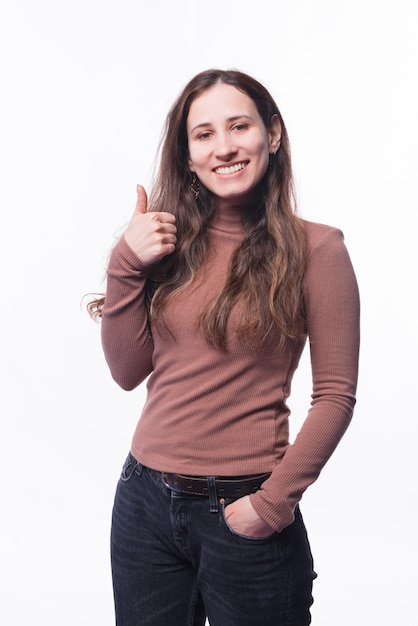 Portret van gelukkige jonge vrouw die duim opdagen en glimlachen