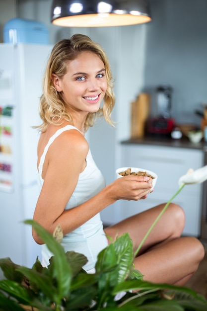 Portret van gelukkige jonge vrouw die ontbijt in keuken hebben