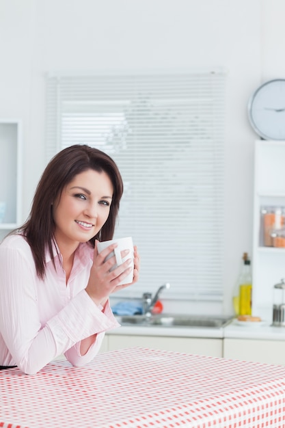 Portret van gelukkige jonge vrouw met een koffiekopje