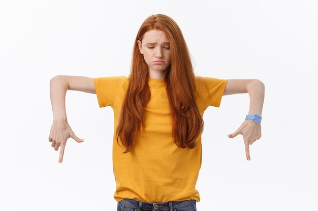 Portret van gelukkige jonge vrouw stond geïsoleerd over witte muur