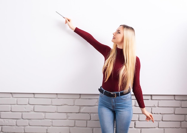 Portret van gelukkige jonge zakenvrouw vrouw in de buurt op witte muur