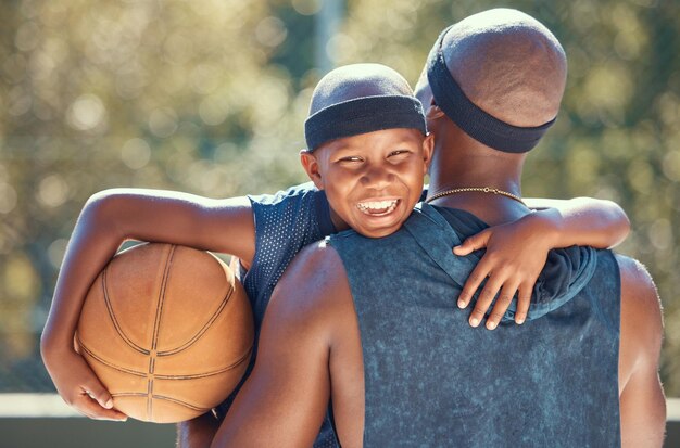 Portret van gelukkige jongen met vader en basketbal buiten na training of oefening Zwarte vader die zijn jongen draagt na het sporten in een club of rechtbank in de zomer met een schattige glimlach