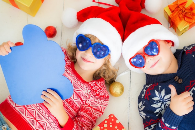 Portret van gelukkige kinderen met kerstversiering. Twee kinderen die plezier hebben thuis