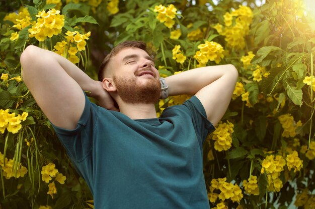 Portret van gelukkige knappe baarde jongen positieve man met baard ruikt mooi geel