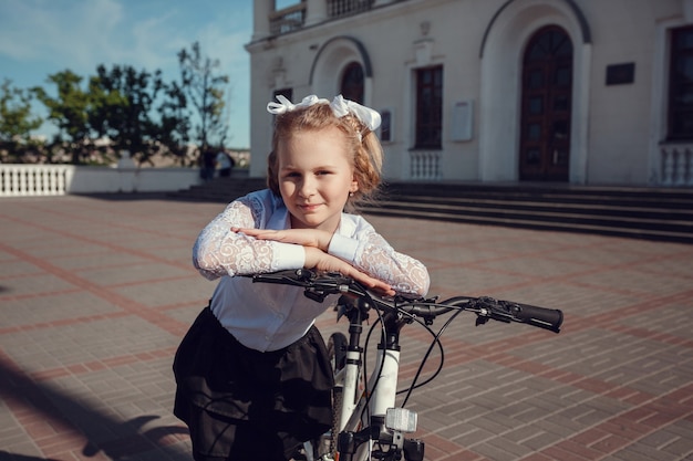 Portret van gelukkige mode kleine kinderen plezier met fiets in de stad.