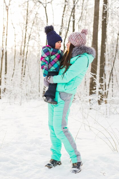 Portret van gelukkige moeder en baby in winterpark