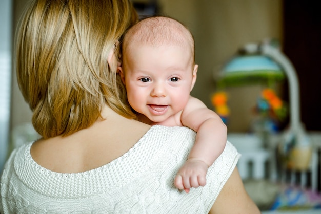 Portret van gelukkige moeder en baby thuis. het kind is 2 maanden