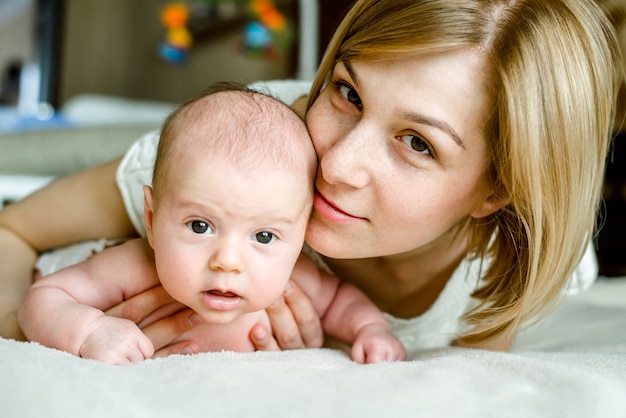 Foto portret van gelukkige moeder en baby thuis.