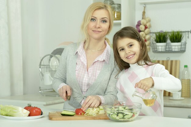 Portret van gelukkige moeder en dochter koken in de keuken