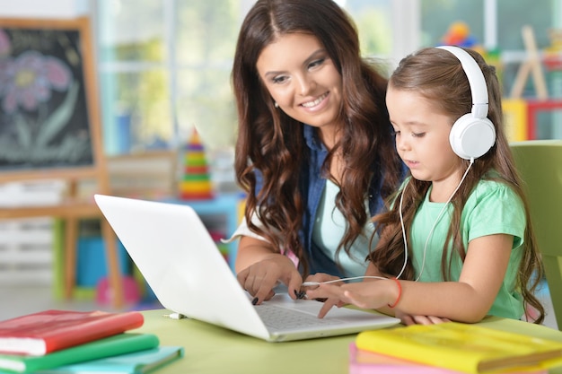 Portret van gelukkige moeder en dochter met behulp van laptop