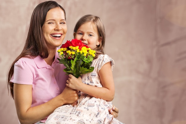 Portret van gelukkige moeder en dochter met bloemen