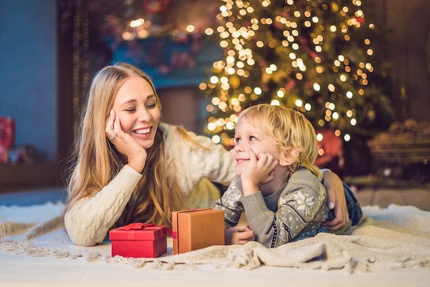 Portret van gelukkige moeder en schattige jongen Kerstmis vieren. Nieuwjaars vakantie