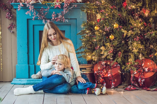 Portret van gelukkige moeder en schattige jongen, kerstmis vieren. peuter met moeder